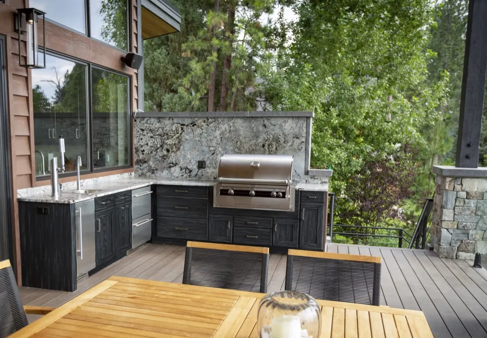 Cuisine extérieure NatureKast avec armoires résistantes aux intempéries sur une terrasse en forêt
